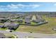 A dynamic aerial view of a suburban area featuring modern homes, well-groomed lawns, and a distant skyline at 1880 Bonser Rd, Minneola, FL 34715