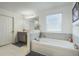 Bright bathroom featuring a vanity, a soaking tub with tiled surround and natural light at 1880 Bonser Rd, Minneola, FL 34715