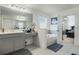 Bright bathroom featuring a large mirror, vanity, and a soaking tub with tiled surround at 1880 Bonser Rd, Minneola, FL 34715