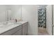 Bathroom featuring dual sinks, gray cabinets, and shower with patterned curtain at 1880 Bonser Rd, Minneola, FL 34715