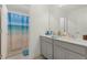 Well-lit bathroom featuring double sinks and a shower with a beach-themed curtain at 1880 Bonser Rd, Minneola, FL 34715