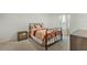 Cozy bedroom with decorative metal bed frame, side table, and plush carpeting at 1880 Bonser Rd, Minneola, FL 34715