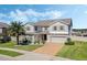 Charming two-story home showcases a brick driveway, well-manicured lawn, and appealing landscaping at 1880 Bonser Rd, Minneola, FL 34715