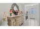 Bright foyer featuring an elegant mirror, ornate dresser, and view of the front door with decorative glass panels at 1880 Bonser Rd, Minneola, FL 34715