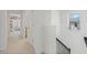 Upstairs hallway featuring neutral carpet, stairs, and a bedroom entrance at 1880 Bonser Rd, Minneola, FL 34715