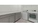 Laundry room featuring washer and dryer, gray cabinets, and vinyl flooring at 1880 Bonser Rd, Minneola, FL 34715