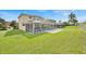 Spacious backyard featuring a screened-in pool and lush green lawn, perfect for outdoor relaxation and entertaining at 210 Vista Loop, Davenport, FL 33897