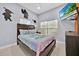 Comfortable bedroom featuring two windows, a ceiling fan, and whimsical wall decals at 210 Vista Loop, Davenport, FL 33897