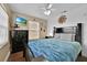 This is a nice bedroom with a ceiling fan, a TV, and blue bedding at 210 Vista Loop, Davenport, FL 33897