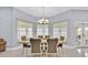 Formal dining room featuring tile floors, chandelier, and bright natural light from a bay of windows at 210 Vista Loop, Davenport, FL 33897
