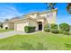 Well-manicured lawn and shrubbery compliment the two-story home featuring an attached two-car garage at 210 Vista Loop, Davenport, FL 33897