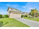 Two-story home with a paved driveway, a two-car garage, and manicured green lawn at 210 Vista Loop, Davenport, FL 33897