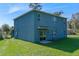 Exterior view of the blue house with windows and a sliding glass door, with a spacious backyard at 219 Meghan Cir, Deland, FL 32724