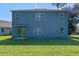 Exterior view of the back of the house with windows and a sliding glass door, with a spacious backyard at 219 Meghan Cir, Deland, FL 32724