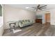 Comfortable living room with wood floors, a ceiling fan, and a sofa for relaxing or entertaining at 219 Meghan Cir, Deland, FL 32724