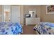 Cozy bedroom with floral twin beds, dresser, and a view of the upper landing at 219 Rosso Dr, Davenport, FL 33837