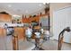 Cozy kitchen nook features a glass table and chairs, adjacent to stainless steel appliances and wood cabinets at 219 Rosso Dr, Davenport, FL 33837