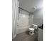 A clean bathroom featuring a bathtub with shower, toilet, and a gray tiled floor at 2207 Antigua Pl # 736, Kissimmee, FL 34741