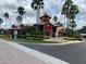 Community clubhouse featuring palm trees, mature landscaping, and a fountain at 2207 Antigua Pl # 736, Kissimmee, FL 34741