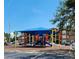 Community playground with a shade structure and view of multi-story apartment homes at 2207 Antigua Pl # 736, Kissimmee, FL 34741