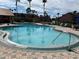 Community pool featuring several mature palms and ample space for lounge seating at 2207 Antigua Pl # 736, Kissimmee, FL 34741