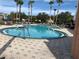 Community pool featuring palm trees and ample space for lounge seating with tables at 2207 Antigua Pl # 736, Kissimmee, FL 34741