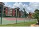 Community tennis court with a lush lawn, mature landscaping, and multi-story apartments at 2207 Antigua Pl # 736, Kissimmee, FL 34741