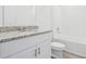 Bright bathroom features granite countertops, white cabinets, and a shower-tub combination at 2310 White Tail St, Davenport, FL 33837