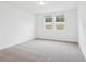Bright bedroom featuring neutral carpet, fresh paint, and well-lit with two windows at 2310 White Tail St, Davenport, FL 33837