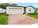 A front exterior view showing the garage and the brick driveway at 2310 White Tail St, Davenport, FL 33837