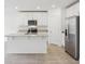 White kitchen features a large island, stainless steel appliances, and modern finishes at 2310 White Tail St, Davenport, FL 33837