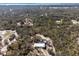 Expansive aerial shot of the home nestled within a lush, wooded landscape, offering privacy and a serene setting at 2466 R E Byrd Rd, Frostproof, FL 33843