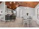 Charming dining area featuring a white table and chairs, complemented by tile flooring and a wood ceiling at 2466 R E Byrd Rd, Frostproof, FL 33843
