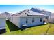Exterior view of the house featuring solar panels, windows, and a well-maintained lawn at 249 Hamlet Loop, Davenport, FL 33837