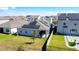 Back exterior showcasing solar panels, manicured lawn, fenced yard, and a covered patio at 249 Hamlet Loop, Davenport, FL 33837