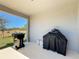 An outdoor back porch with a trash can and covered grill at 249 Hamlet Loop, Davenport, FL 33837