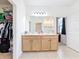 Bright bathroom featuring double sinks and a large mirror with access to a shower room at 249 Hamlet Loop, Davenport, FL 33837
