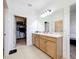 Bright bathroom featuring double sinks and a large mirror with access to a walk-in closet at 249 Hamlet Loop, Davenport, FL 33837