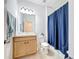 Bathroom featuring a vanity, mirror, toilet, and blue shower curtain at 249 Hamlet Loop, Davenport, FL 33837