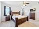 The bedroom features a dark wood frame bed, ceiling fan, two windows and a dresser at 249 Hamlet Loop, Davenport, FL 33837