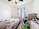 Bright bedroom featuring a ceiling fan, large window, and a white bed frame at 249 Hamlet Loop, Davenport, FL 33837