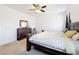 Bedroom featuring a dark wood frame bed, ceiling fan, and natural light from windows at 249 Hamlet Loop, Davenport, FL 33837