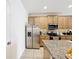 Bright kitchen featuring stainless steel appliances, granite countertops, and tile flooring at 249 Hamlet Loop, Davenport, FL 33837