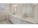 Bathroom with dual sinks, white cabinets, and stone counters at 25 Lakeshore Blvd, St Cloud, FL 34769