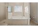 Beautiful bathroom featuring a standalone tub, a glass block window, and walk in shower at 25 Lakeshore Blvd, St Cloud, FL 34769