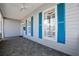 Inviting front porch with gray tile flooring and bright blue shutters at 25 Lakeshore Blvd, St Cloud, FL 34769