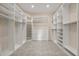 Spacious walk-in closet with custom built-in shelving and drawers with neutral walls and tile floors at 25 Lakeshore Blvd, St Cloud, FL 34769