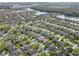 This aerial view showcases a densely populated neighborhood with winding roads, lush trees, and scenic views of lakes and nature at 2933 White Cedar Cir, Kissimmee, FL 34741