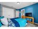 Stylish blue bedroom with a closet, a television on a table, and ensuite access to the bathroom at 2933 White Cedar Cir, Kissimmee, FL 34741