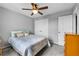 Cozy bedroom featuring a bed, ceiling fan, closet, dresser, and soothing gray walls at 2933 White Cedar Cir, Kissimmee, FL 34741